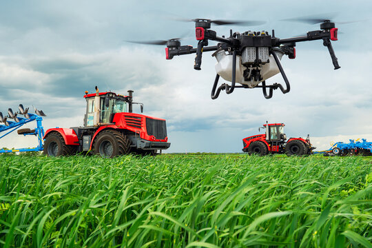 tractors cultivate the soil in rural areas. The concept of technological agriculture. Modern technologies in agriculture. An industrial drone flies over a green field