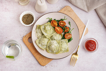 Plate of tasty ravioli and glass with water on white background