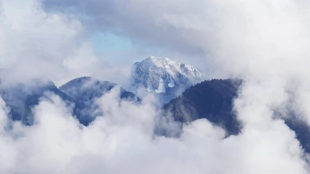Washington National park with cloud sea and bright sunlight. Northern Cascades mountain summit landscape in cinematic clouds. Parallax drone shot of mountaintop covered in clouds. Rocky mountains view