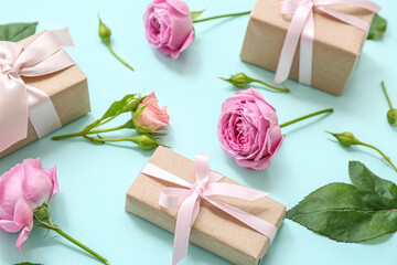 Composition with wrapped gift boxes decorated with peonies flowers on cyan background