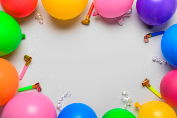 Frame made of balloons and party horns on white background