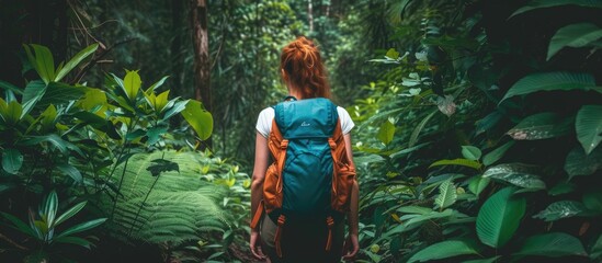 An adventurous solo female backpacker explores the enchanting forest while carrying a blue backpack.