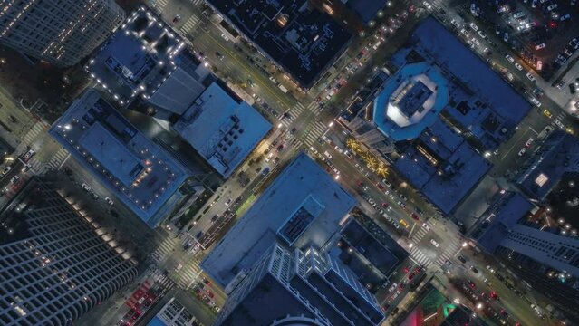 Seattle business district, Washington USA. Top down aerial of tall office and apartment buildings in modern downtown in twilight. Drone shot of city traffic in downtown streets Birds eye overhead view