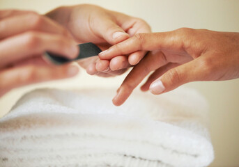 Hands, manicure and filing nails in salon for beauty treatment, relax or care. Closeup, spa and...