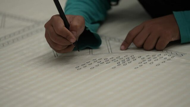 a close-up view of the batik design sketching process