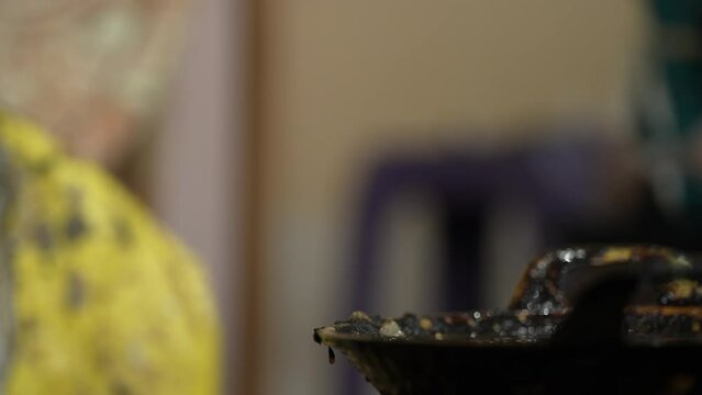 Close-up view of the process of making batik with canting