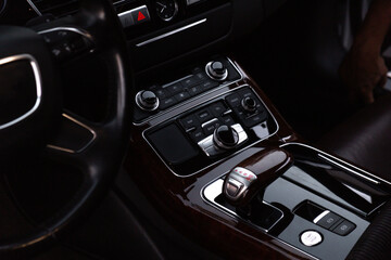 Interior of modern luxury car. Details of automatic transmission gear shift, multimedia control...