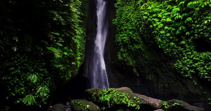 Scenic Leke Leke waterfall plunges through leafy foliage on cliff in Bali jungle