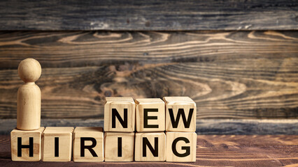 The row of wooden cubes with 'new hiring' text and a wooden peg doll
