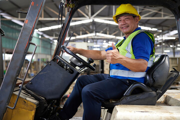 senior worker driving forklift and thumbs up pose in the factory