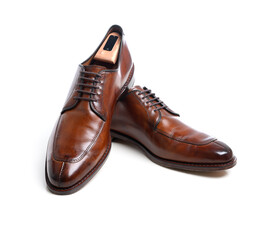 A pair of brown leather mens dress shoes on white with copy space