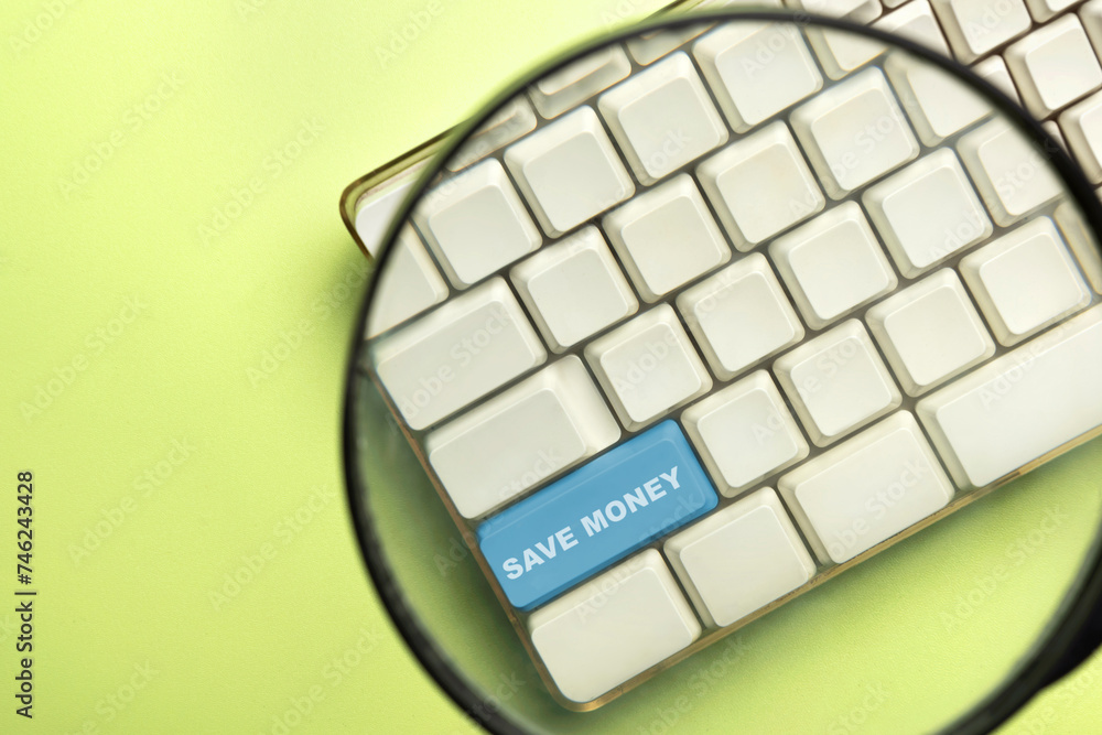 Poster the magnifying glass focuses on the keyboard button with 'save money' text