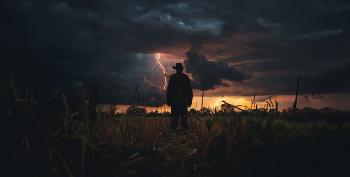 A photorealistic image of a farmer, silhouetted against a stormy sky, standing defiantly in their field. Lightning illuminates the landscape.