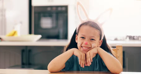 Zelfklevend Fotobehang Girl, child and bunny ears for portrait in home to smile for culture, holiday or festive celebration. Kid, face paint and art for rabbit, Easter and happy for creativity, play or mask in family house © peopleimages.com