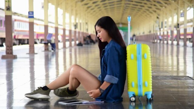 Asian young woman traveller sitting with luggage look at maps in Airplane lounge. Female travel passenger by plane tourist baggage. Tourism trip women journey vacation.