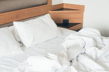 White pillow with rumpled bed - obrazy, fototapety, plakaty