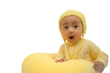 Baby expression and sweet gesture. Six months old baby wearing all yellow clothes smiling and having fun with yellow pillow