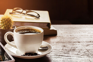 Coffee cup,glasses and smart phone on wooden table