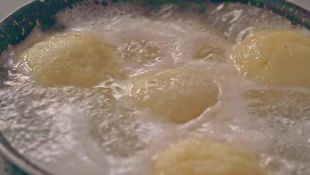 Ambient motion of traditional german potato dumplings (Kartoffelkl&ouml;&szlig;e) boiling in a pot showing the candid peaceful moment of home life and winter comfort food