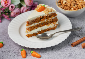 Homemade carrot cake made with walnuts, iced with cream cheese. Sweet dessert.