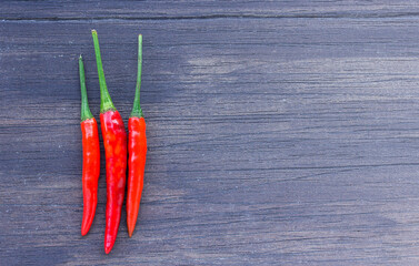 Fresh red chili on an old wooden background.