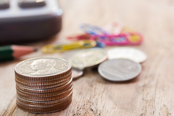 stack of assorted coins on the wooden table