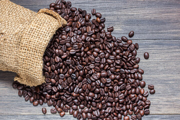 Coffee beans, sack on wooden background. top view