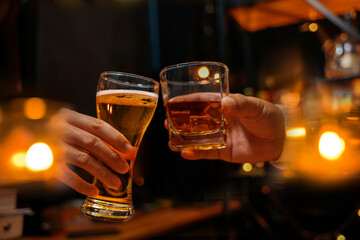 food and drink male friends are happy drinking beer and clinking glasses at a bar or pub.