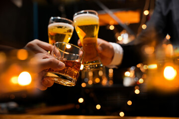 food and drink male friends are happy drinking beer and clinking glasses at a bar or pub.