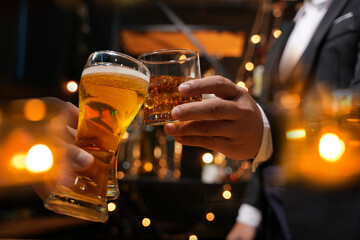 food and drink male friends are happy drinking beer and clinking glasses at a bar or pub.