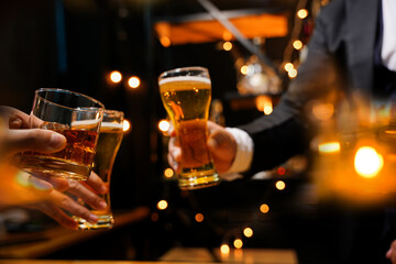 food and drink male friends are happy drinking beer and clinking glasses at a bar or pub.