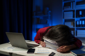 Asian businesswoman is tired, sleepy and bored from sitting at a desk for a long time working on a...