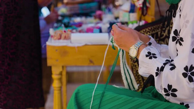 Woman hands knit clothes at market in Uzbekistan.