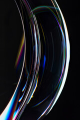 Colorful Light Refractions on Curved Glass Surface Against Black Background