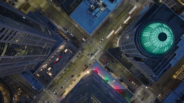 Drone shot of city traffic in downtown streets. Birds eye overhead view Seattle business district, Washington USA. Top down aerial of tall office and apartment buildings in modern downtown in twilight