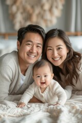 Obraz premium A man and a woman are laying on a bed with a baby between them, bonding and relaxing together