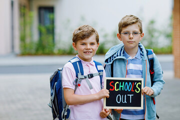 Two little kid boys with backpack or satchel. Schoolkids on the way to school. Healthy children,...