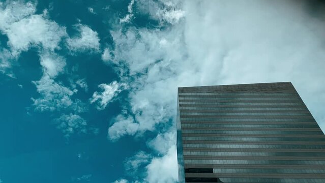 mirrored building with clouds passing quickly