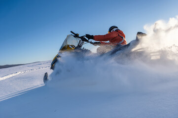 Athlete on a snowmobile moving in the winter forest in the mountains of the Southern Urals