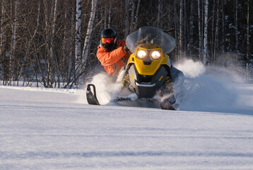 Athlete on a snowmobile moving in the winter forest in the mountains of the Southern Urals