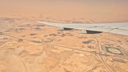 An airplane is flying over a desert landscape