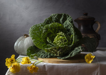Still life with savoy cabbage and pumpkin on a dark background