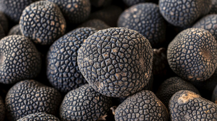 From a top-down perspective, black truffles, esteemed for their rich aroma and exquisite flavor, are displayed, showcasing their unique texture and culinary appeal.