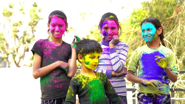Indian kids playing with colours or asian children celebrating holi. festival of colours