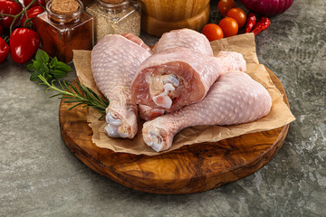 Raw uncooked chicken drumsticks over board