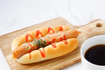 おいしそうなフランクフルトソーセージパン（ホットドッグ）とコーヒーでランチタイム
