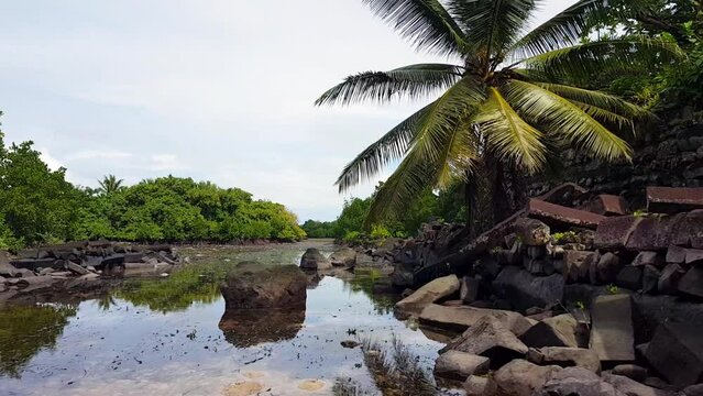 Scenic view of lagoon canal surrounding the ancient city of Nan Madol with big stone outer wall in Pohnpei, Federated States of Micronesia