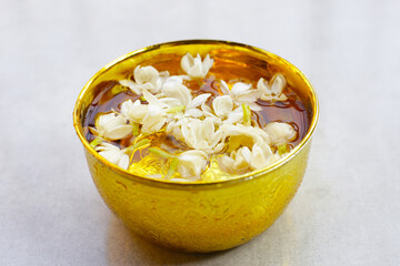 Water with jasmine flowel in golden bowl. Thai tradition, Songkran festival concept