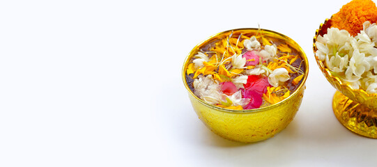 Water with jasmine flower, marigold petal and rose petal in golden bowl. Thai tradition, Songkran festival concept