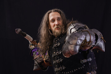 A brave medieval knight with a distinctive appearance swings for throwing a spear on a black background